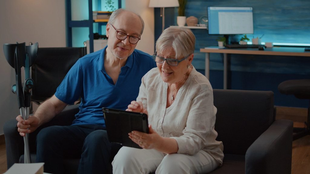 An older couple talking with a physician on a tablet at home